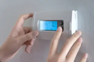 homeowner adjusting indoor room temperature